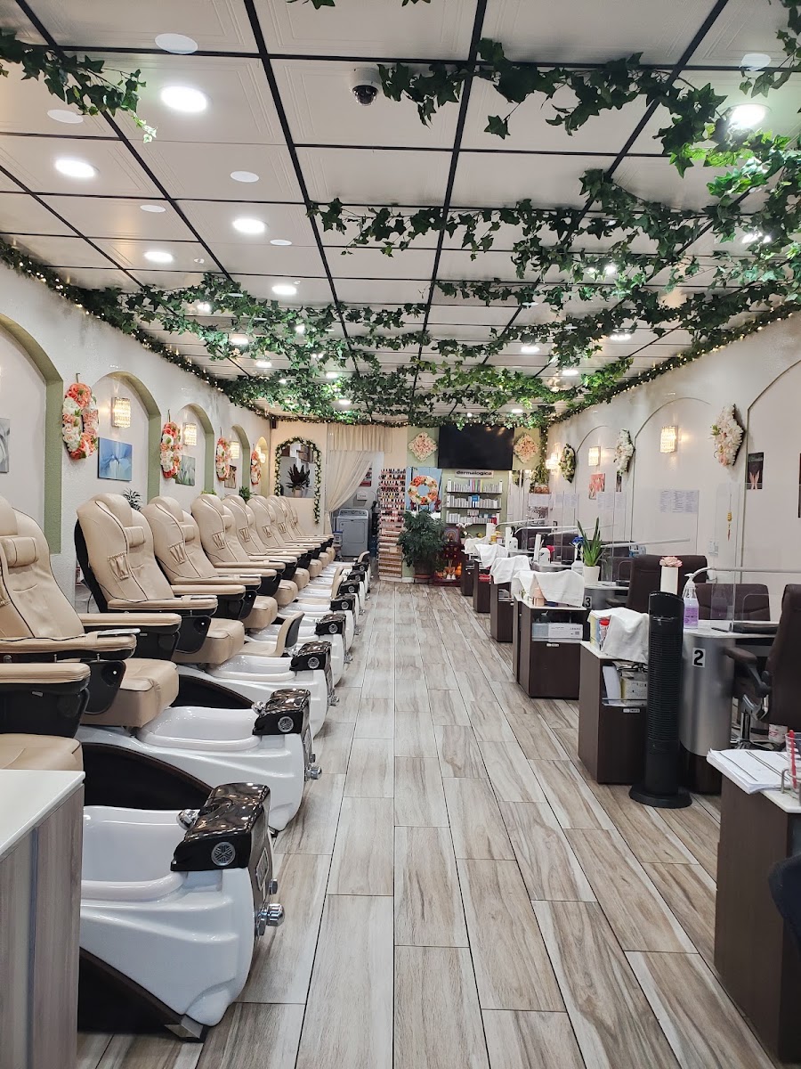Long row of pedicure chairs beneath hanging vines