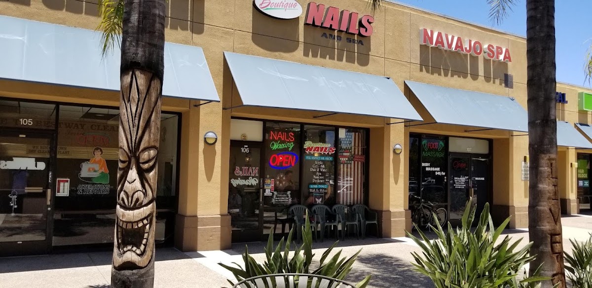 Storefront in Navajo Shopping Center with the Boutique Nails and Spa sign and neon Open sign