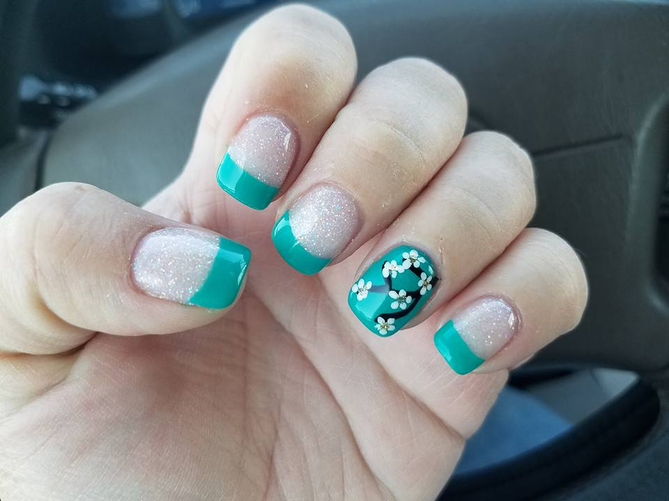 Teal French tips with glitter and a floral accent nail